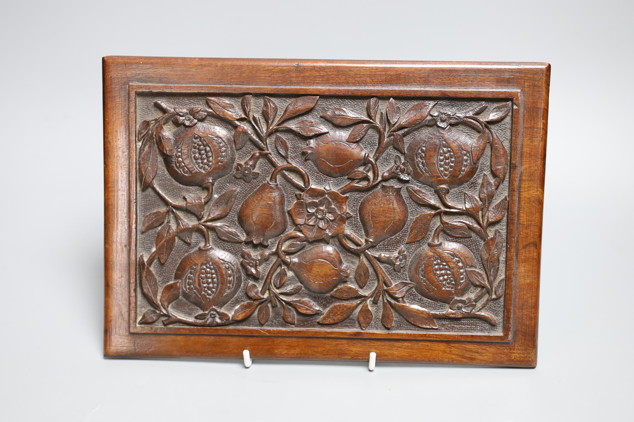 An Aesthetic period carved walnut ‘pomegranates’ panel, 28 cms wide x 19 high